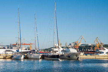 White yachts in the port waiting. On the sea is calm.