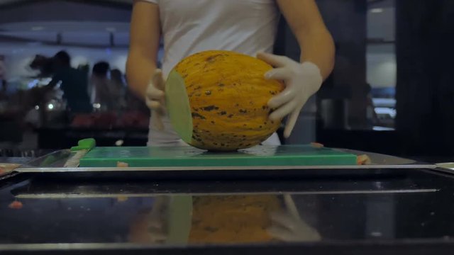 The cook cut a delicious sweet melon in the hotel restaurant.