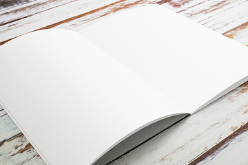 Opened magazine or brochure on grunge wooden background.