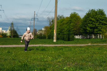 Fototapeta premium Handsome boy of six years playing, jumping, running, smiling in the park. Place for text