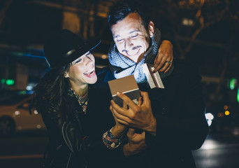Man and woman smiling looking at their smartphone. technology concept