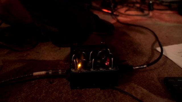 Hands musician tuning buttons on music control before rock performance