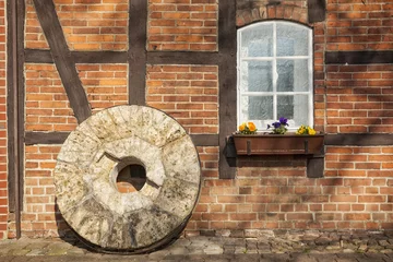 Wall murals Mills Old millstone in front of half-timbered house