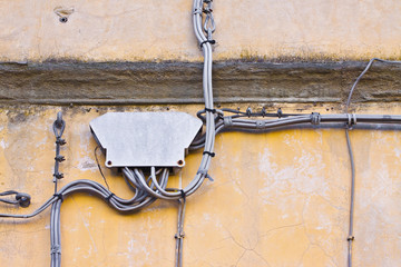Electrical power and telephone cables fixwd to a plaster wall with protection junction box