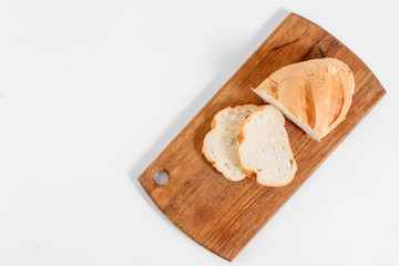 Top view of slices of white bread on a kitchen board, on a white background.