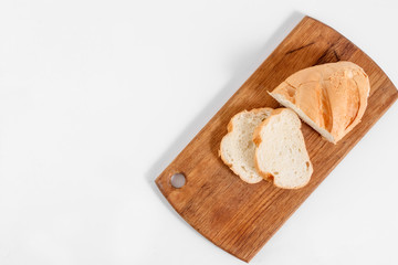 Top view of slices of white bread on a kitchen board, on a white background.