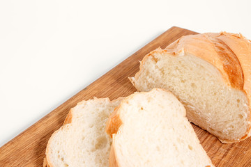 Side view of slices of white bread on a kitchen board, on a white background.