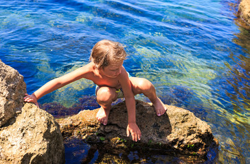 Boy on the beach stones.