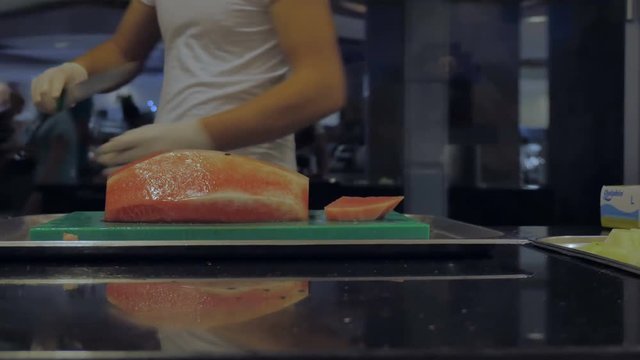 The cook cut a delicious sweet watermelon in the hotel restaurant.