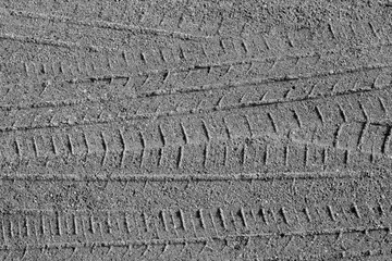Tyre tracks on sandy road in black and white