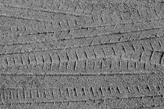 Tyre tracks on sandy road in black and white