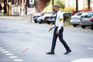 Blind Man Wearing Armband Walking With Stick