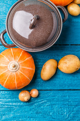 Picture of pot with a lid, potatoes, pumpkin, onions