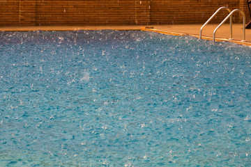 Fototapeta na wymiar Swimming pool with Background of old brick wall in raining