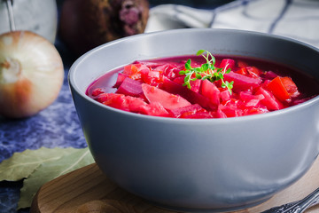 Immune boosting winter vegetable  soup dark on blue background. Selective focus, copy space, close up.
