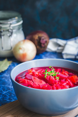 Roasted beetroot soup or borscht on dark blue background. Selective focus, copy space, close up.