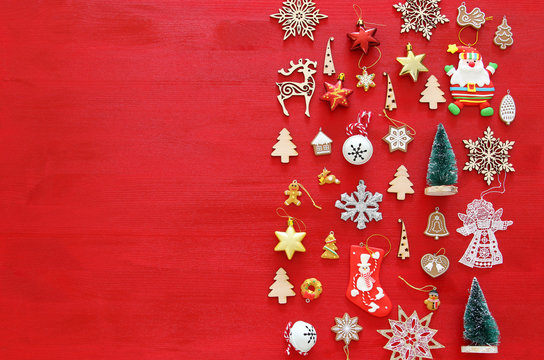 Top view image of christmas festive decorations on red wooden background. Flat lay.