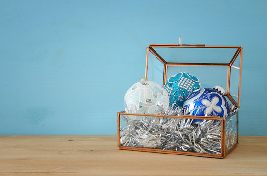 Image of christmas festive decorations in the vintage glass box on wooden table.
