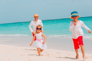 father with little son and daughter play, run at beach