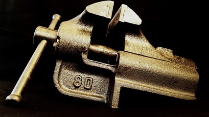 Metal table vise clamp isolated on black background