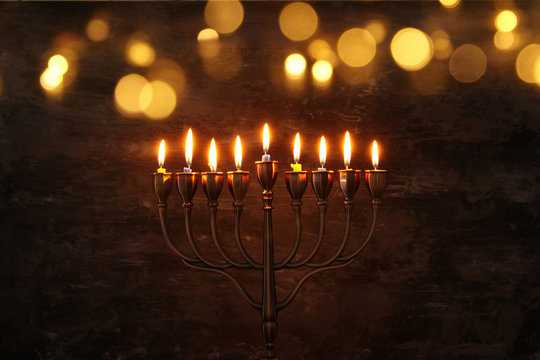 Low key image of jewish holiday Hanukkah background with menorah (traditional candelabra) and burning candles