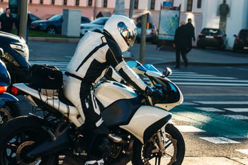 Biker on white racing motorcycle on the road