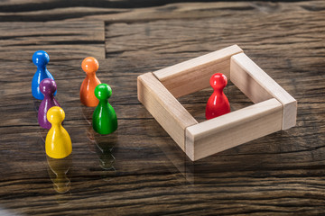 Multi Colored Figurine Pawn And Wooden Blocks On Desk