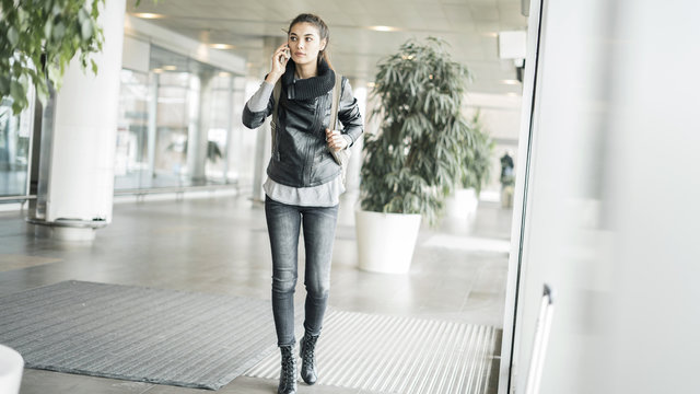 Passenger walking  at the airport  and talking mobile phone