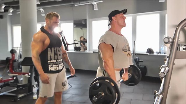 Strong man doing barbell snatch exercise at the gym in slow motion.