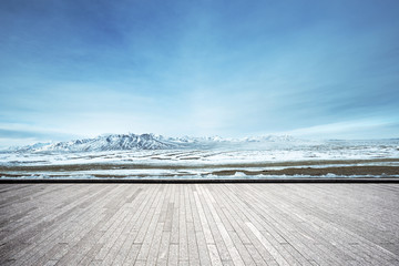 empty brick floor with snow mountains