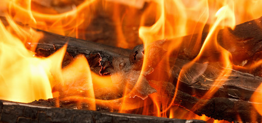 Burning and glowing charcoal with open hot flame and smoke