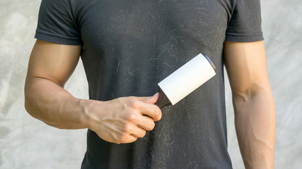 Man holding a hair removal roller.