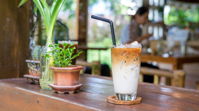 Iced latte on a wooden table in a cafe.