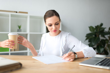 woman giving coffee in paper cup