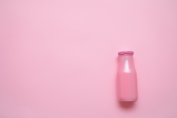 pink glass bottle on pastel pink paper background