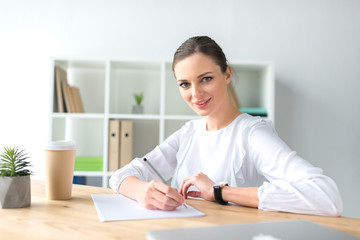 happy businesswoman sitting at table