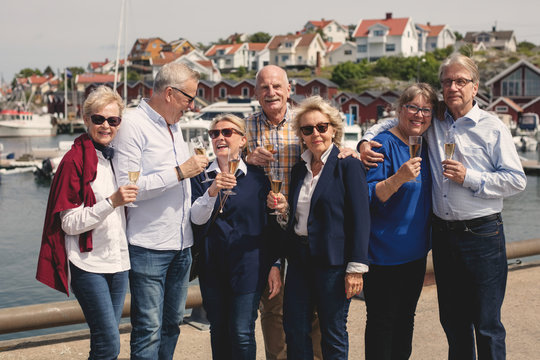 Senior friends enjoying champagne on pier