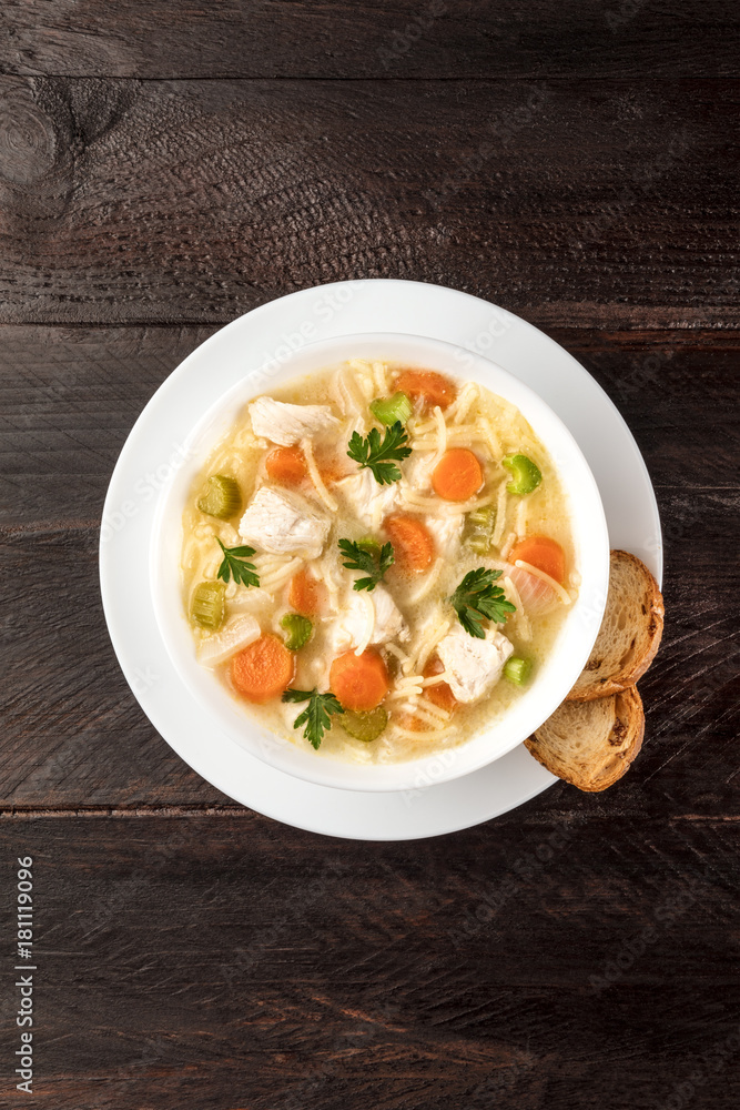 Wall mural chicken soup with noodles, overhead photo with copyspace