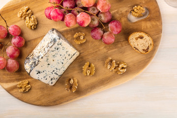 Blue cheese with grapes, nuts, and toasts, and copyspace