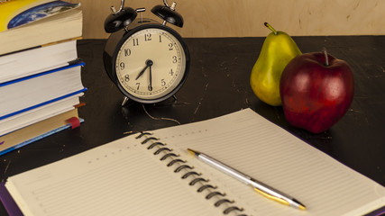 Books, pen, notebook and fruit on the table concept of study