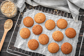 Cooling rack with delicious oatmeal cookies on wooden table