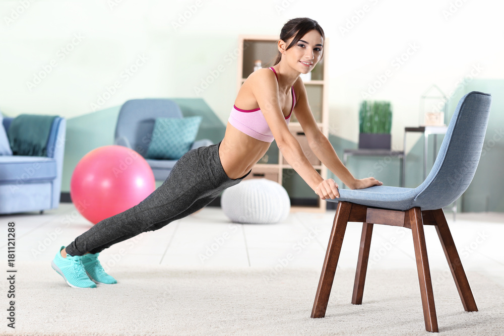 Poster Beautiful young woman doing exercises with chair at home