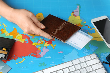 Woman holding passport with arrival card on world map