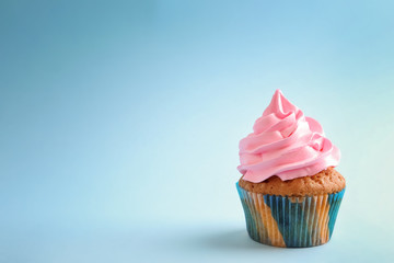 Tasty cupcake on color background