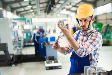 Male worker and quality control inspection in factory