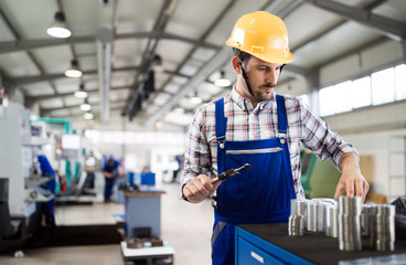 Male worker and quality control inspection in factory