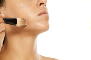 young beautiful woman applied liquid base with a brush