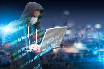 The double exposure image of hacker hold a laptop overlay with source code image and blurred cityscape is backdrop. the concept of cyber attack, virus, malware, and cyber security.