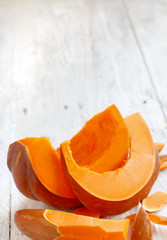 Pumpkin slices on a wooden background