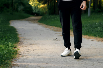 Morning jog in the park, men's legs close-up copy space